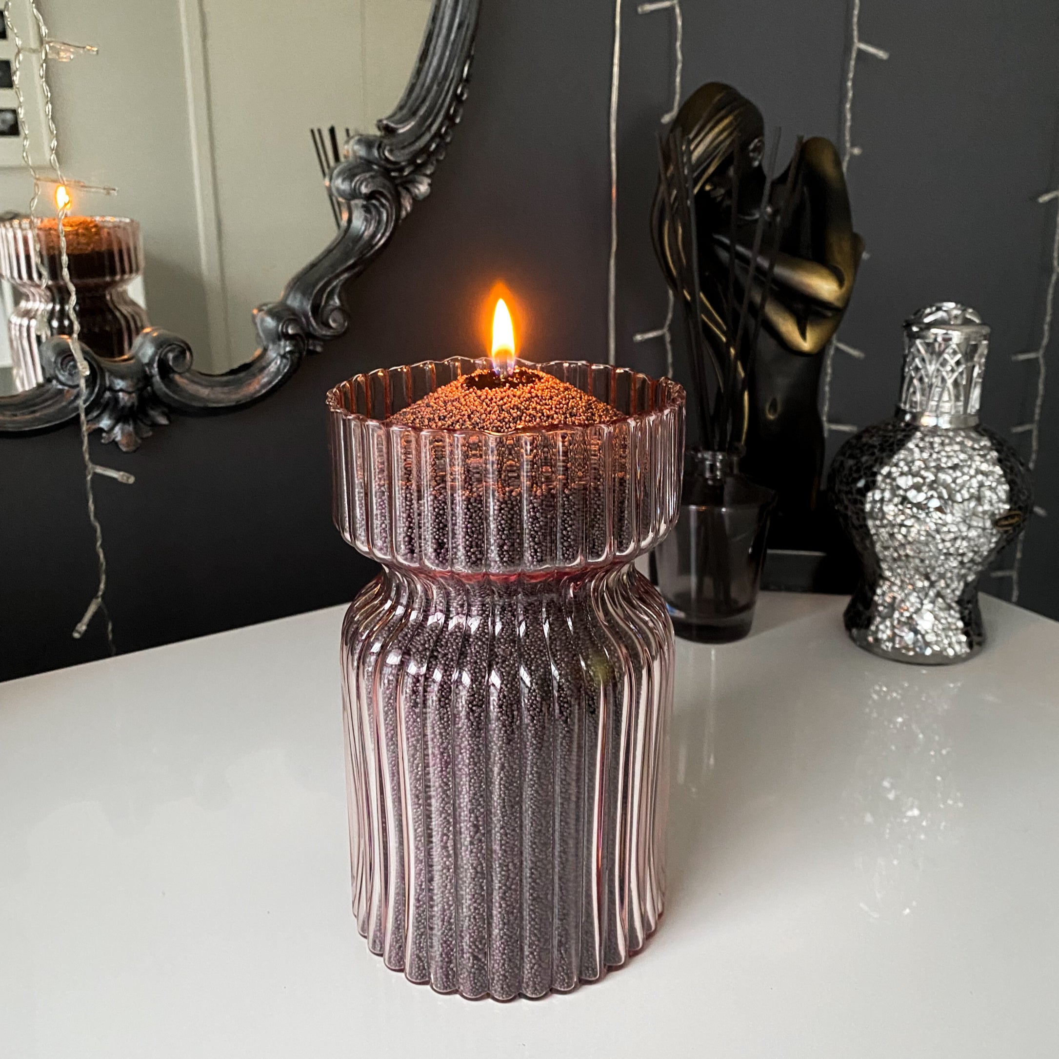 Decorative vessel filled with charcoal sandwax. Simple yet unique candle for any room.