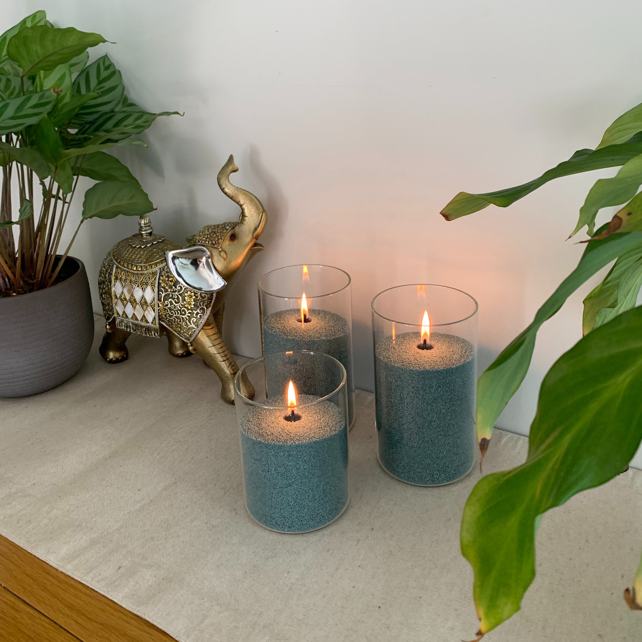 Three glass sand wax candles filled with Dark pine coloured wax, perfect addition to the hallway table