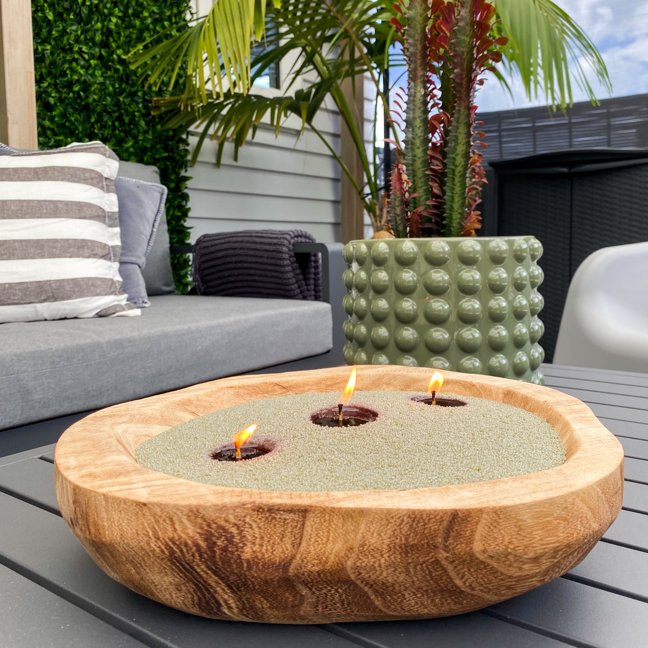 Wooden olive sand wax candle outdoors. Stunning candle feature that is clean burning.