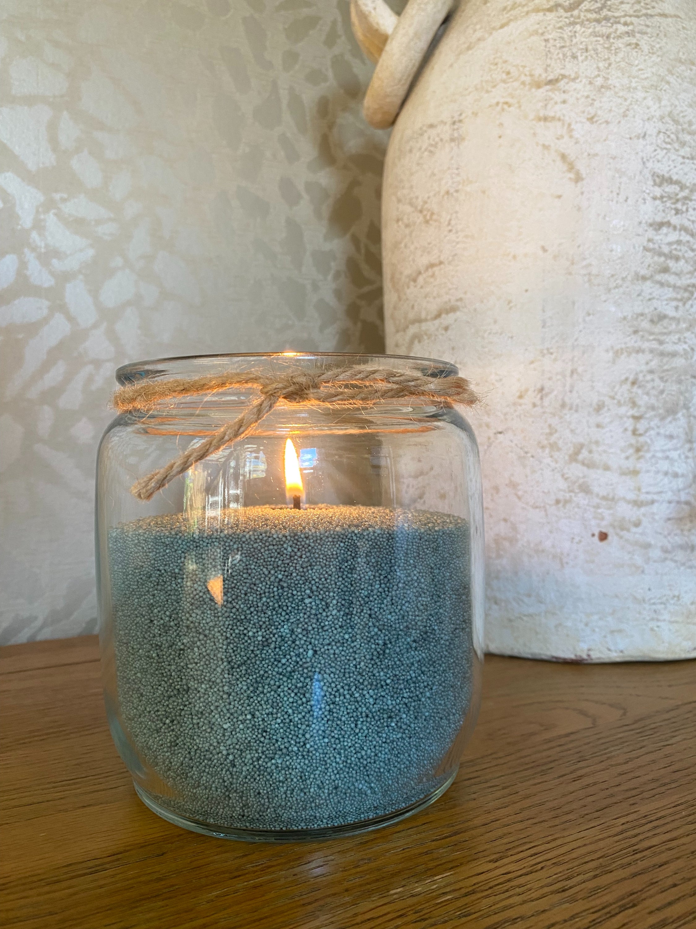 Glass candle holder with a lit dark pine coloured sandwax